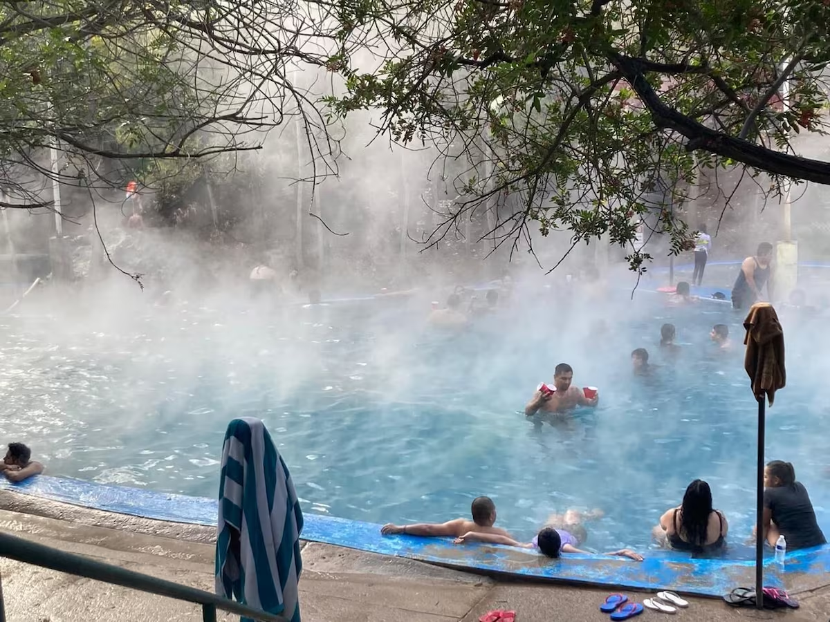 Steamy outdoor hot spring with bathers
