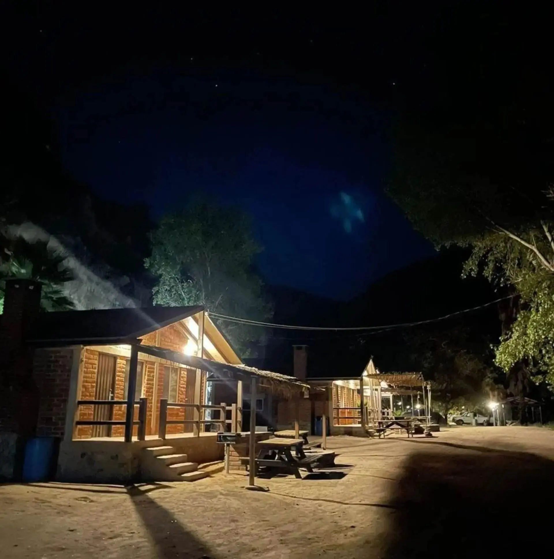 Lit cabins along a quiet road at night